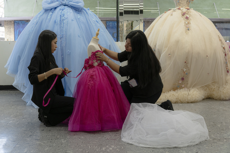 Two employees at a dress shop adjust a mannequin for display in downtown Laredo on April 9, 2026.