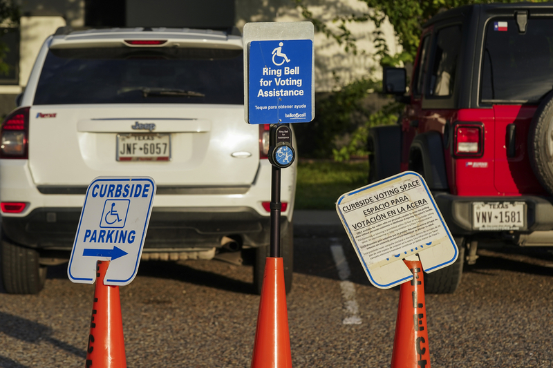 A bell to call for voting assistance is set up at a polling site on the first day of early voting in Alamo on Oct. 19.