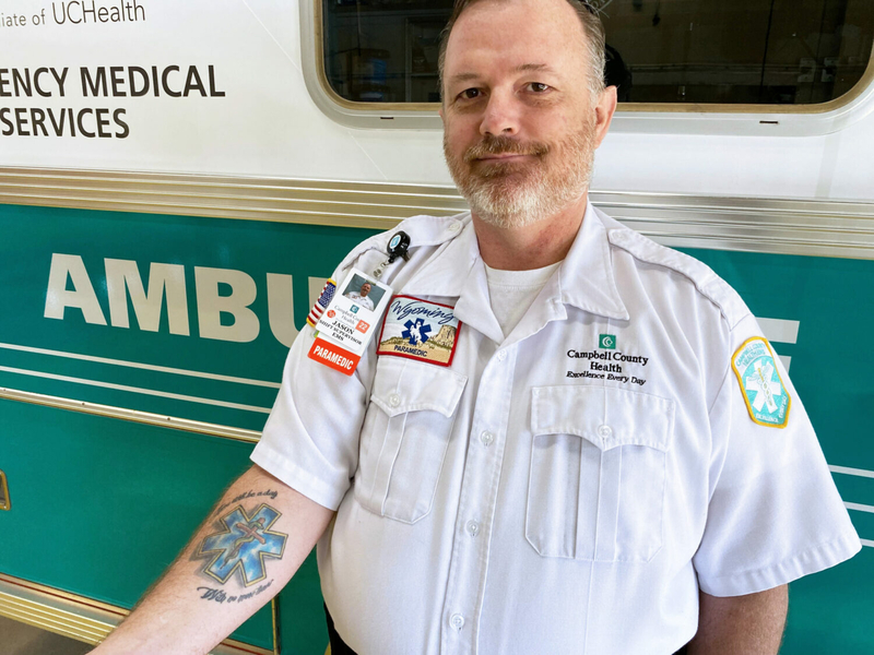 Jason Frye shows off his emergency-medical-services-themed tattoo. Frye helped start a community paramedicine program that plans to serve three rural counties in northeastern Wyoming. (Arielle Zionts/KFF Health News)