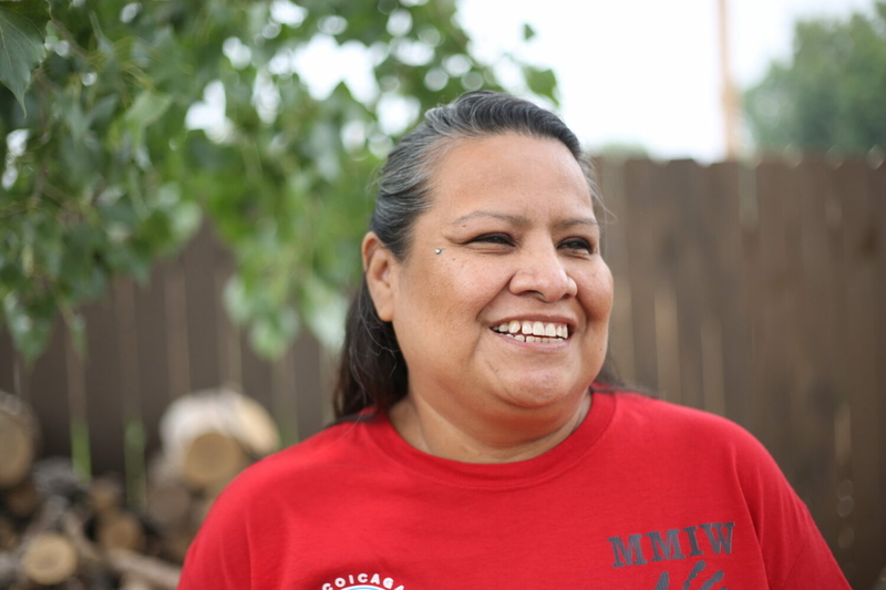 Toni Handboy, a counselor for Wakpa Waste Counseling Services, stands outside Inka Najin Oti (“The Red House) addiction recovery house in Eagle Butte on the Cheyenne River Reservation on Sunday, June 16, 2023. (Makenzie Huber, South Dakota Searchlight)