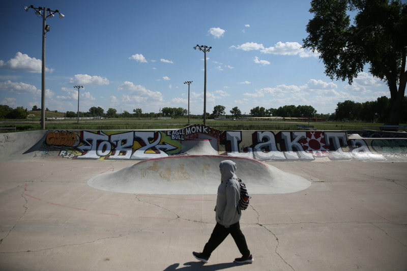 A student walks home from the Pine Ridge High School through the skate park in Pine Ridge on Monday, Aug. 28, 2023. (Makenzie Huber, South Dakota Searchlight)