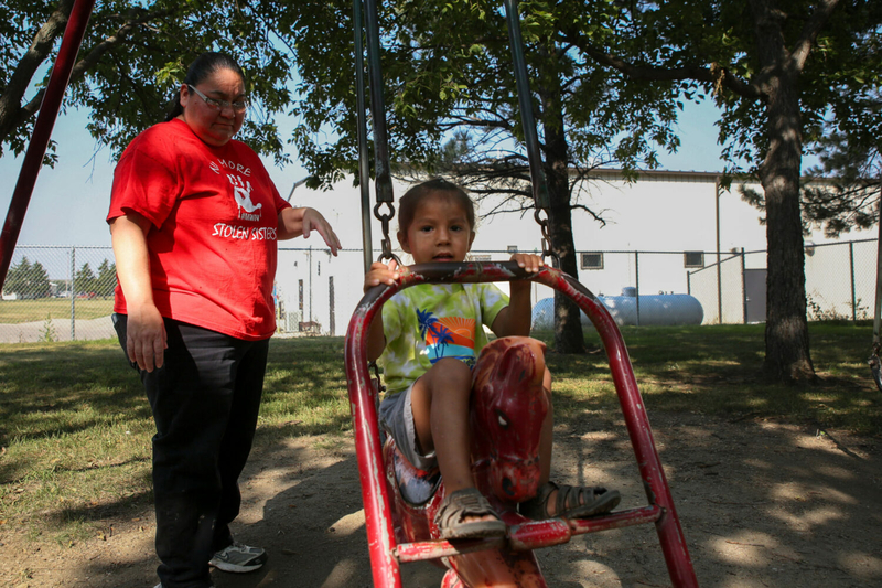 Natasha Eagle Star pushes her son Noran on a swing at the Winner City Park on Tuesday, Aug. 29, 2023. (Makenzie Huber, South Dakota Searchlight)