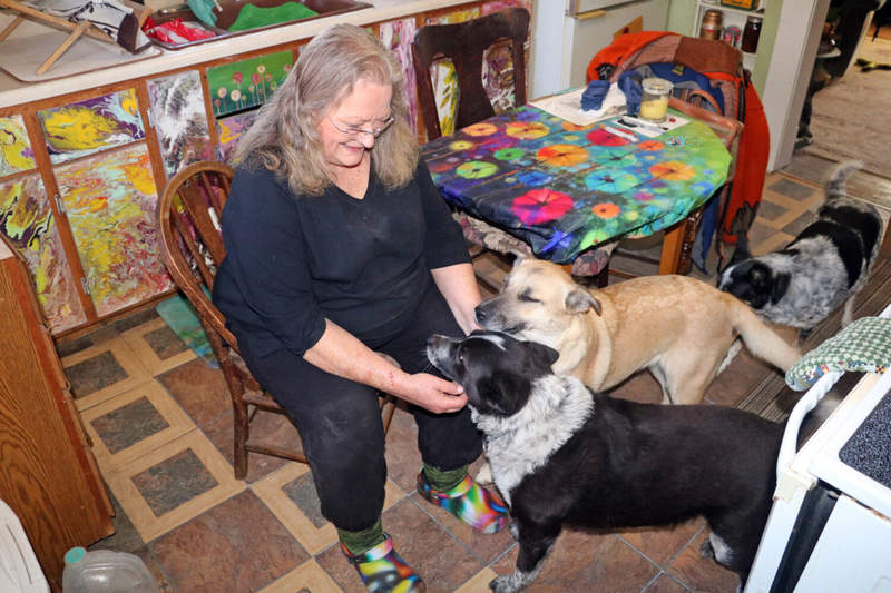 Shirley Schumacher shares some time with her three rescue dogs in the kitchen of her Oral home, located 16 miles southeast of Hot Springs in Fall River County. (Brett Nachtigall/Fall River County Herald-Star)