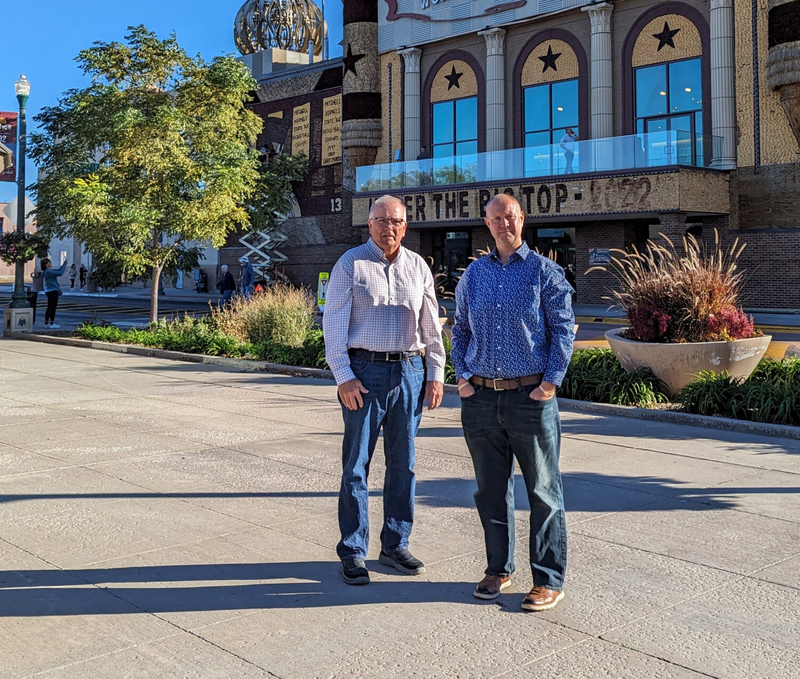 Mitchell Area Housing's Terry Sabers, left, and Mike Lauritsen of the Mitchell Area Economic Development Corp. pose on Oct. 20, 2023 near the Corn Palace in Mitchell. (John Hult/South Dakota Searchlight)