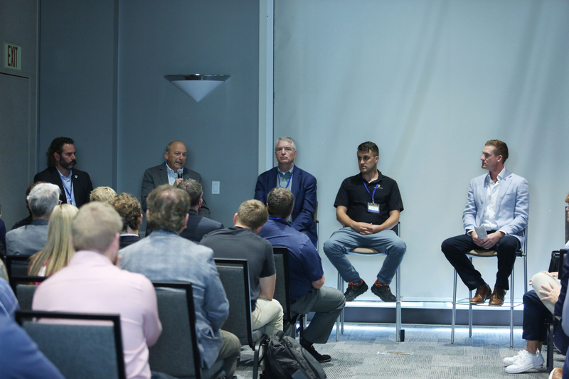 (Left to right) Kent Hartwig, of Gevo; Tom Kersting, of South Dakota Soybean Processors; Brian Bird, of Northwestern Energy; and Nick Phillips, of Applied Digital speak on a panel at the SDSU Land and Lending Conference in Sioux Falls on Oct. 1, 2025. Ty Eschenbaum, of A1 Development Solutions, moderates the panel. (Photo by Makenzie Huber/South Dakota Searchlight)