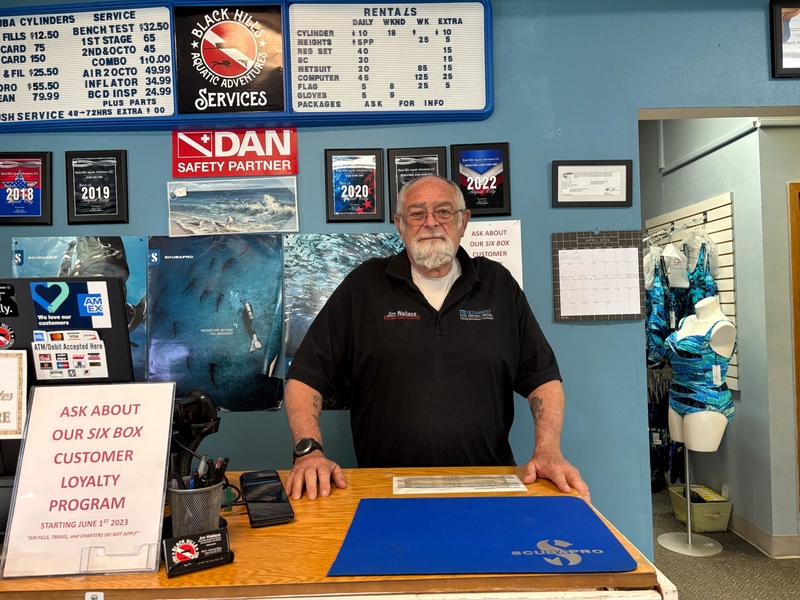 Jim Wallace, 83, is pictured in his Rapid City dive shop. He's volunteered with the Spearfish Ambulance Service for over a decade. (Photo by Meghan O'Brien/South Dakota Searchlight)
