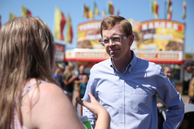 U.S. Rep. Dusty Johnson, R-S.D., speaks with a constituent at the Sioux Empire Fair in Sioux Falls on Aug. 5, 2026. (Photo by Makenzie Huber/South Dakota Searchlight)