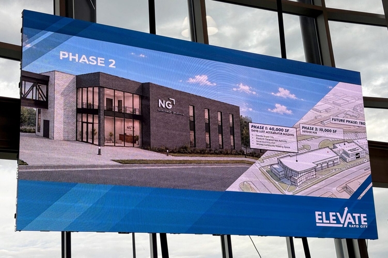 Conceptual drawings of a planned addition to the David Lust Accelerator Building are displayed in the Rapid City building on Sept. 23, 2026, during an announcement that defense contractor Northrop Grumman will anchor the addition. (Photo by Seth Tupper/South Dakota Searchlight)