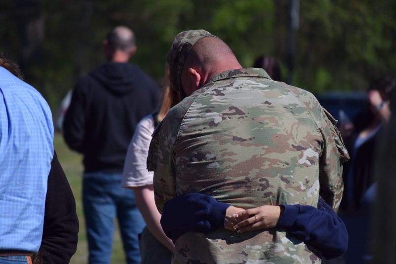A member of the 142nd Field Artillery Brigade hugs a loved one following a sendoff ceremony