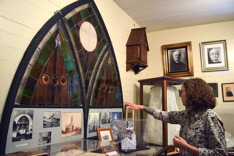 Tontitown Historical Museum Manager Emily Pianalto-Beshears discusses a stained glass window that survived a tornado that destroyed a local church in 1934.