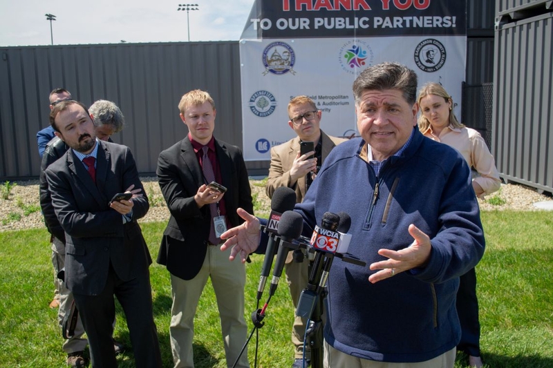 JB Pritzker surrounded by reporters