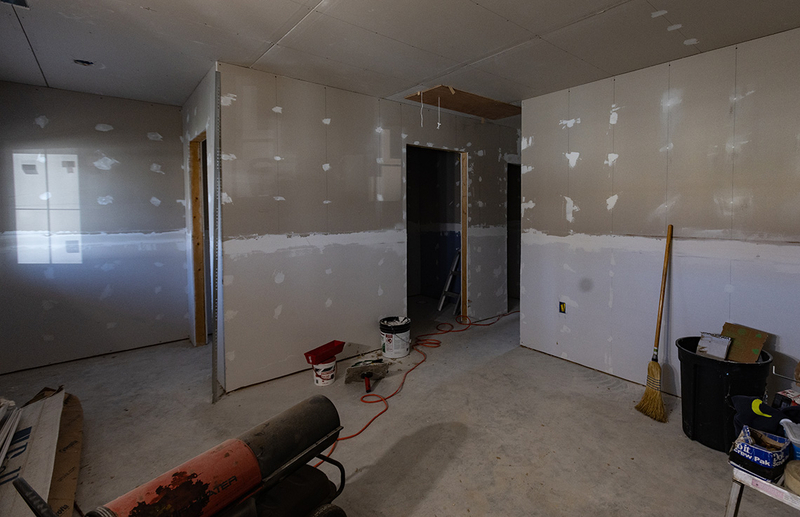 An unfinished room with building and cleaning materials.