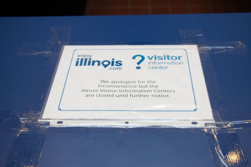 Sign tapped to the front desk reads, "We apologize for the inconvenience but the Illinois Visitor Information Centers are closed until further notice".