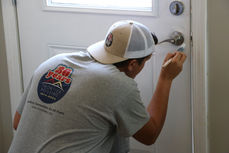 Hunter Plank painting a door.