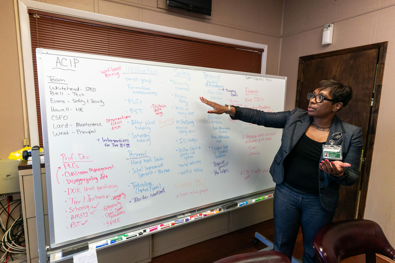 A woman pointing at a whiteboard