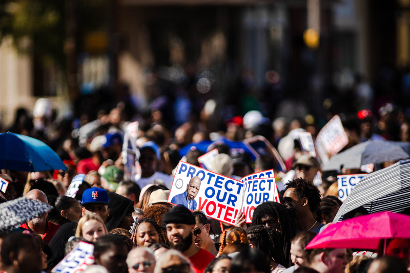 People holding signs urging people to vote