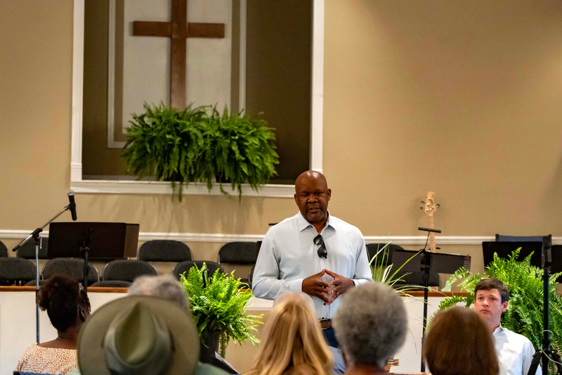 A man in a white shirt addressing a congregation
