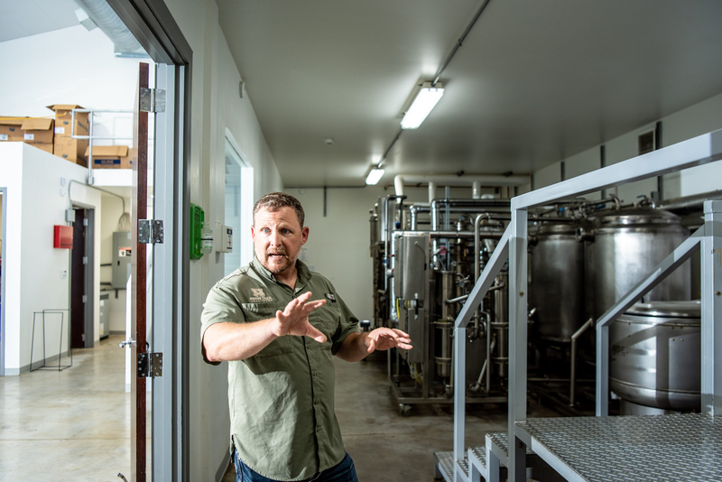 A man gesturing around mechanical equipment