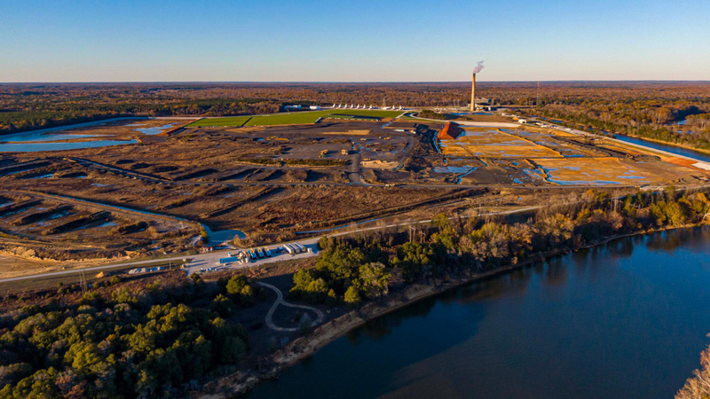 A large pond next to a power plant