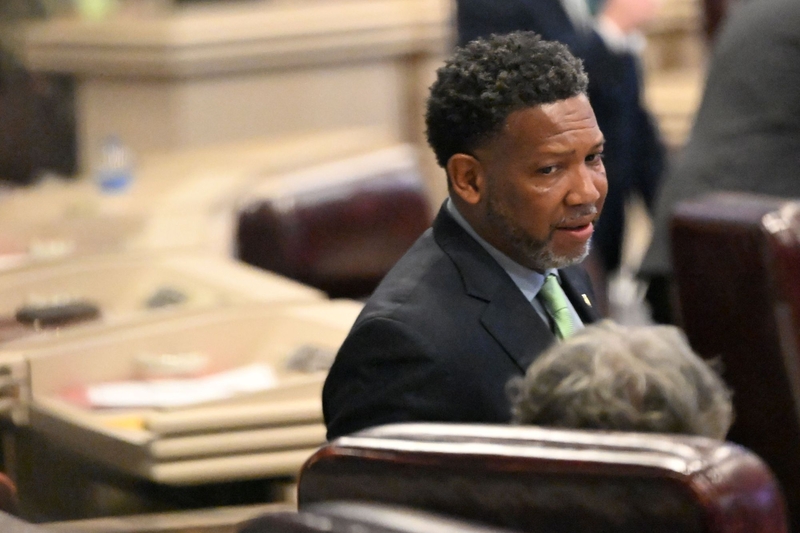 A man in a dark duit and green tie