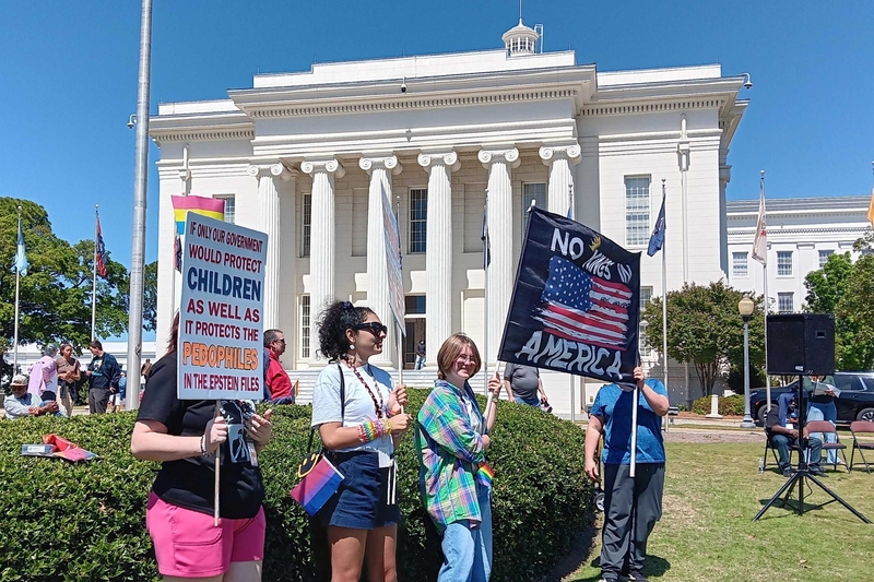 Three people holding signs