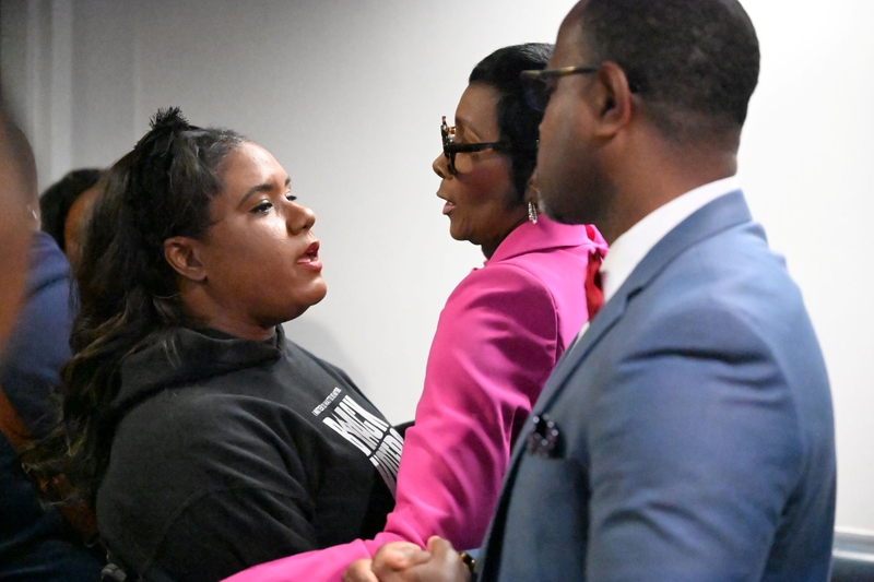 A woman speaking to a woman and a man