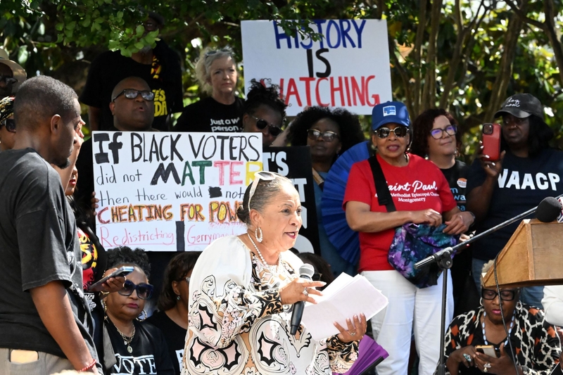 A woman holding a microphone addressing a crowd