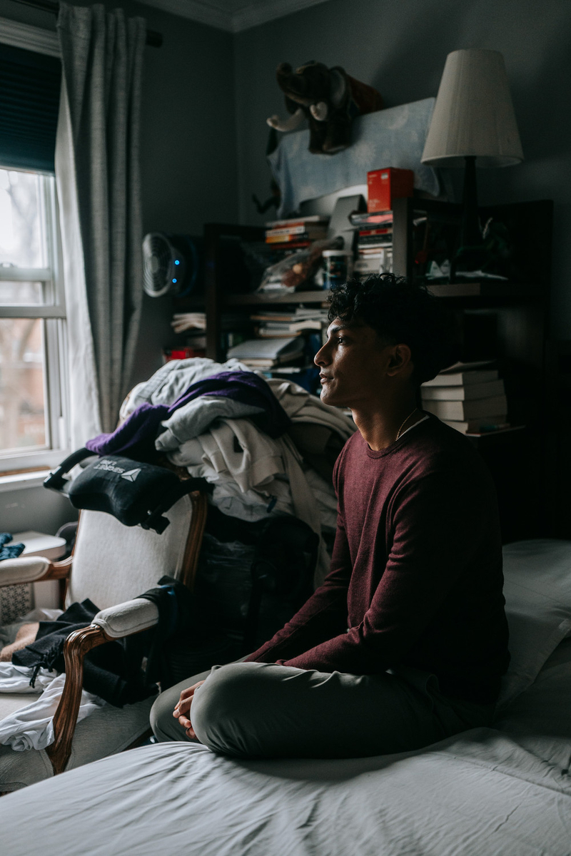 Brandon Bishunauth sits for a portrait inside his family's home.