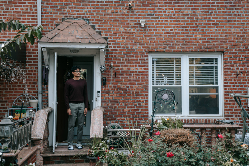 Brandon Karan Bishunauth stands for a portrait outside his family's home.