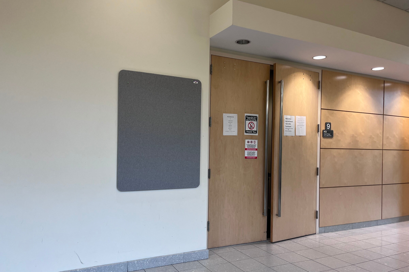 A photo of the outside of a courtroom, with the door closed.