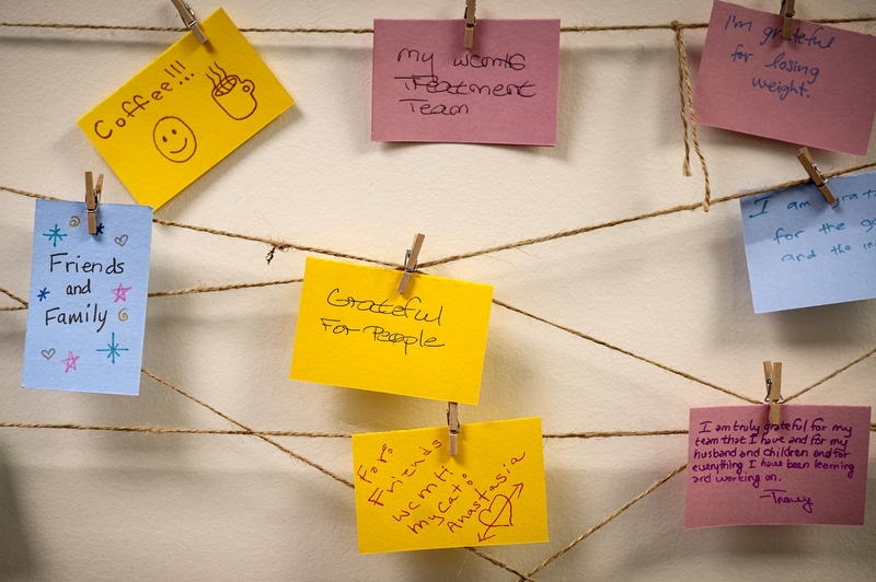 A group of post it notes hanging on a clothesline.