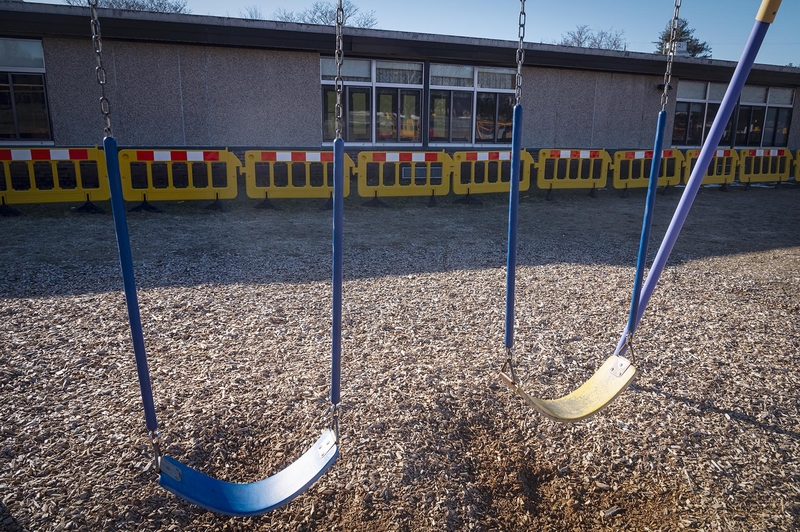 A playground with swings and a fence.