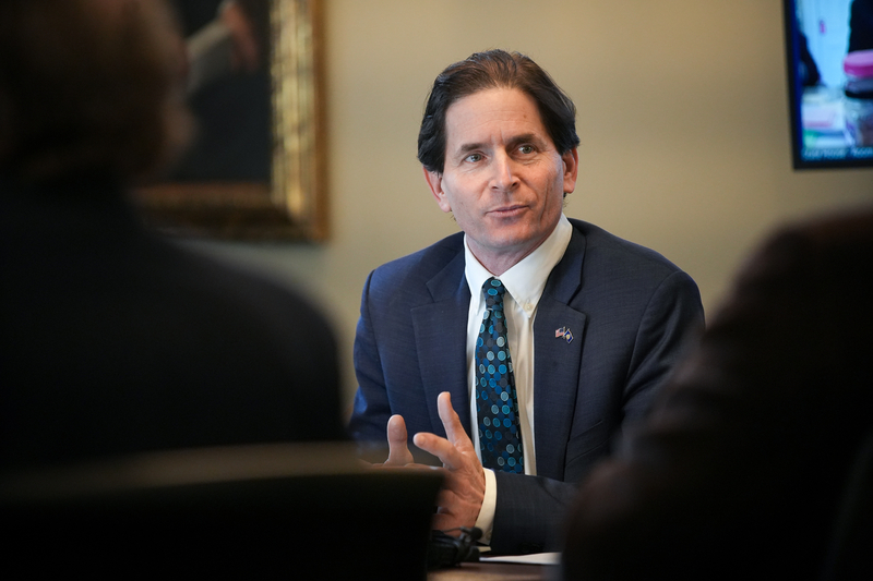 A man in a suit talks to other people.