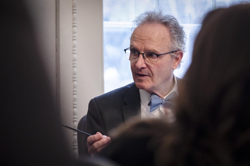A man in a suit and tie is talking to a group of people.