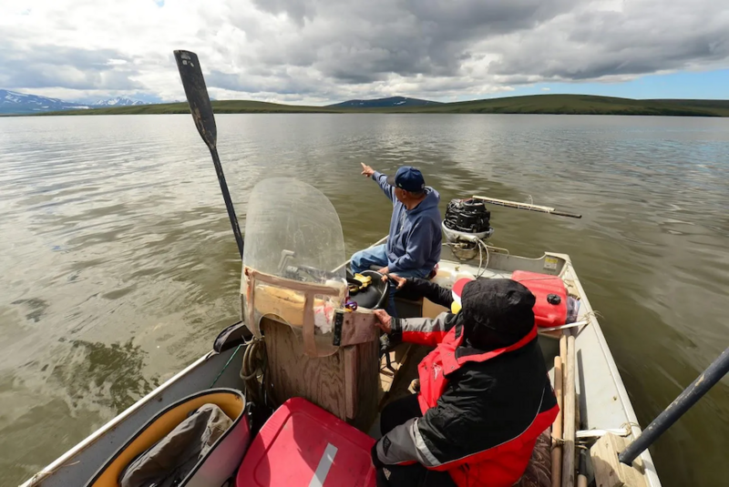 Sylvester Ayek points toward the Kigluaik Mountains and the site of the Graphite One exploration project as his skiff bobs in the Imuruk Basin. (Photo by Berett Wilber for Northern Journal)