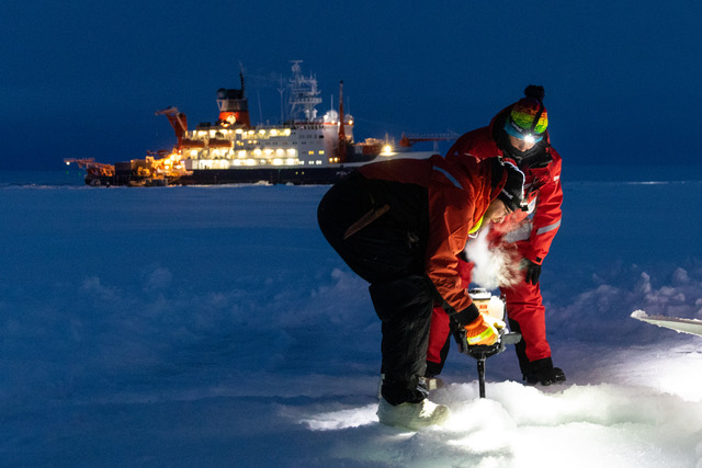 University of Alaska Fairbanks scientist Marc Oggier, front, uses an auger to drill through the sea ice during the 2019 MOSAiC expedition in the central Arctic Ocean. Oggier spent part of the winter collecting ice samples and examining their how their crystals were structured. The images he captured were incorporated into clothing. (Photo by Marcel Nicolaus/Alfred Wegener Institute)