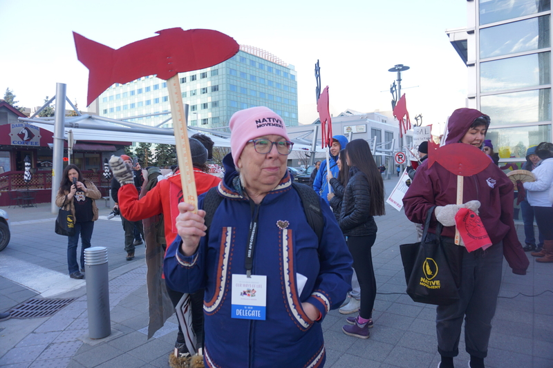 Bev Hoffman of Bethel, a founder of hte Mouther Kuskokwim Tribal Coalition, participates in a rally on Oct. 19, 2023, against the Donlin Gold mine and other resource-extraction projects. Hoffman is a longtime community activist and Yup'ik leader who opposes the mine. The protest was held on the street outside Anchorage's Dena'ina Civic and Convention Center, where the Alaska Federation of Natives annual convention was underway. (Photo by Yereth Rosen/Alaska Beacon)
