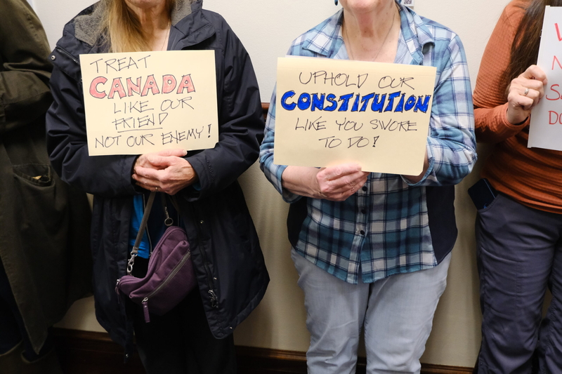 Demonstrators hold signs for U.S. Sen Dan Sullivan on March 20, 2025. (Photo by Corinne Smith/Alaska Beacon)