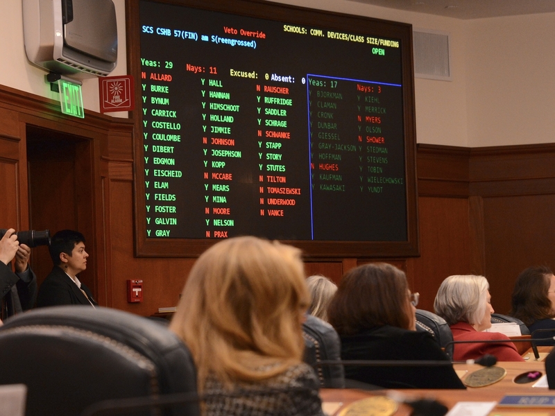 Legislators watch as votes for and against the override of House Bill 57 are displayed on the legislative tally board on Tuesday, May 20, 2025. (Photo by James Brooks/Alaska Beacon)
