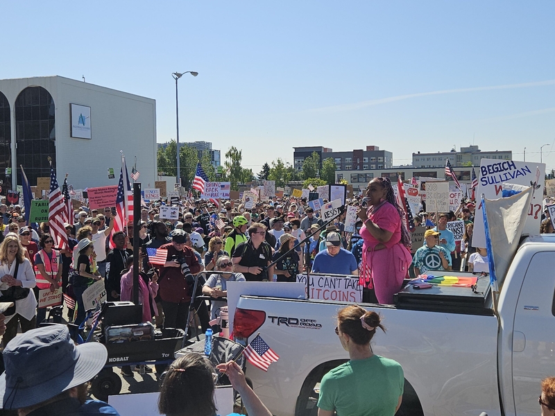 Erin Jackson-Hill, an organizer and executive director of Stand Up Alaska, addresses the crowd of the "No Kings" rally in Anchorage on June 14, 2025 (Photo by Corinne Smith/Alaska Beacon)