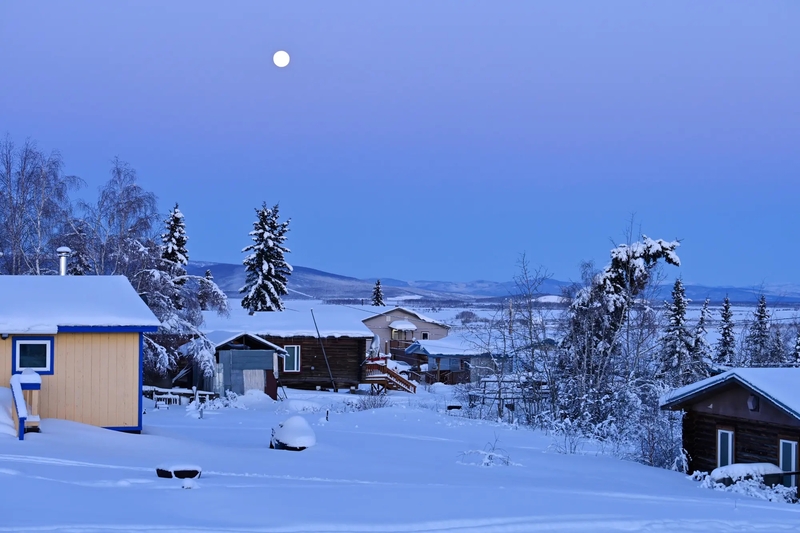The full moon sets over homes in Minto, a small community about 50 miles northwest of Fairbanks, Alaska (Photo by Marc Lester/Anchorage Daily News)