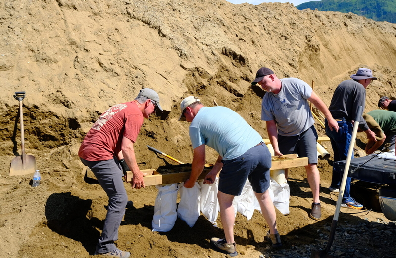 Residents of the Mendenhall Valley shovel and load sand at a sandbag distribution event held on July 26, 2025, by the City and Borough of Juneau and the Central Council of Tlingit and Haida Indian Tribes of Alaska. By 1 p.m. that day, more than 100 cars had checked in at the Dimond Park Field House, according to city officials. Each household was allowed to fill 75 sandbags. The event, one of several held by municipal and Tribe officials, was in anticipation of another glacial outburst flood. (Photo by Corr