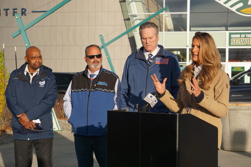 Kelly Loeffler, head of the U.S. Small Business Administration, speaks at an Oct. 29, 2025, news conference held outside the Alaska Airlines Center at the University of Alaska Anchorage campus. Listening to Loeffler are, from left, Willie Nunn, a Seattle-based coordinator for the Federal Emergency Management Agency who was assigned to Alaska; Bryan Fisher, director of the Alaska Division of Homeland Security and Emergency Management; and Gov. Mike Dunleavy. Loeffler spoke about the SBA's plans to make loads