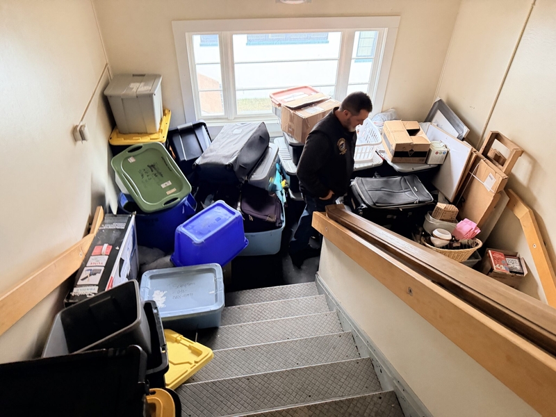 Storage containers are stacked in a stairwell of the Mt. Edgecumbe girls dormitory as the attic is leaking, seen on a legislators' visit on Feb. 6, 2026 (Photo courtesy of the Senate Finance Committee)