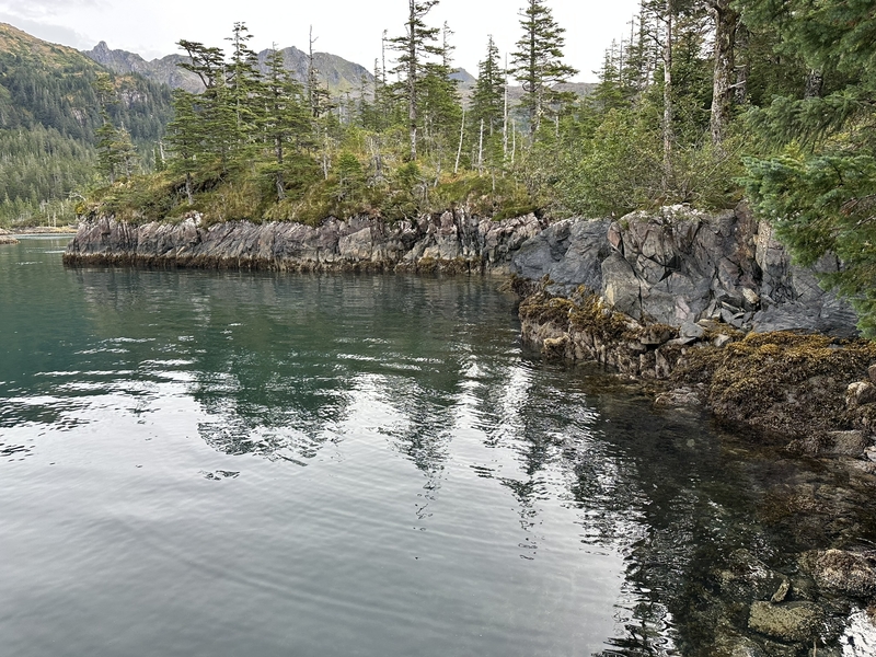A section of rocky shoreline in Herring Pete's Cove is ref;ected in the water. Herring Pete's Cove is now part of Kachemak Bay State Park. (Photo provided by The Conservation Fund)