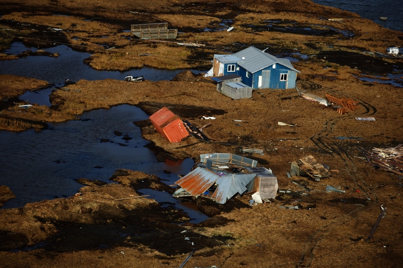 A drifted home on the outskirts of Kipnuk after Typhoon Halong flooded the Western Alaska village, underscoring the scale of erosion and storm damage facing climate-threatened communities.