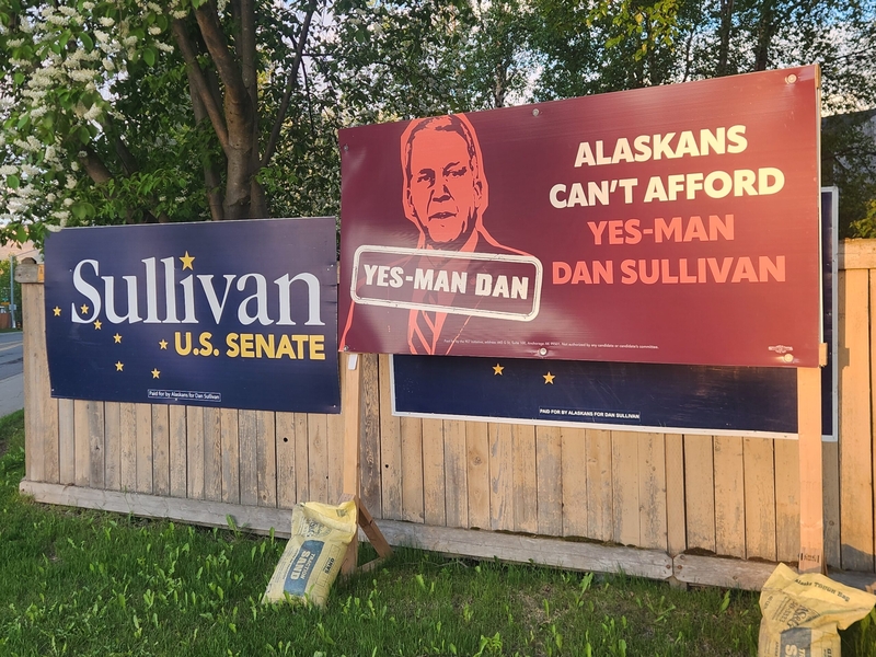 Signs for and against Sen. Dan Sullivan, R-Alaska, are seen in South Anchorage on June 9, 2026. (Photo by Yereth Rosen/Alaska Beacon)
