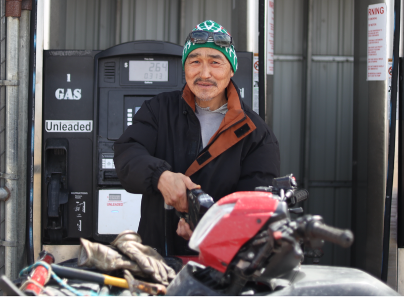 Some Hooper Bay residents, like Jay Bell Sr., purchase a gallon or two of gas at a time. It's "too expensive" to buy more than that, said another resident, Anthony Tinker, after putting $15-worth in his four-wheeler. (Nathaniel Herz/Northern Journal)