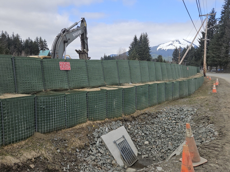 Crews fortify Hesco barriers along the Mendenhall River on Riverside Dr. to prepare for glacial outburst flooding on Apr. 25, 2026. (Photo by Corinne Smith/Alaska Beacon)
