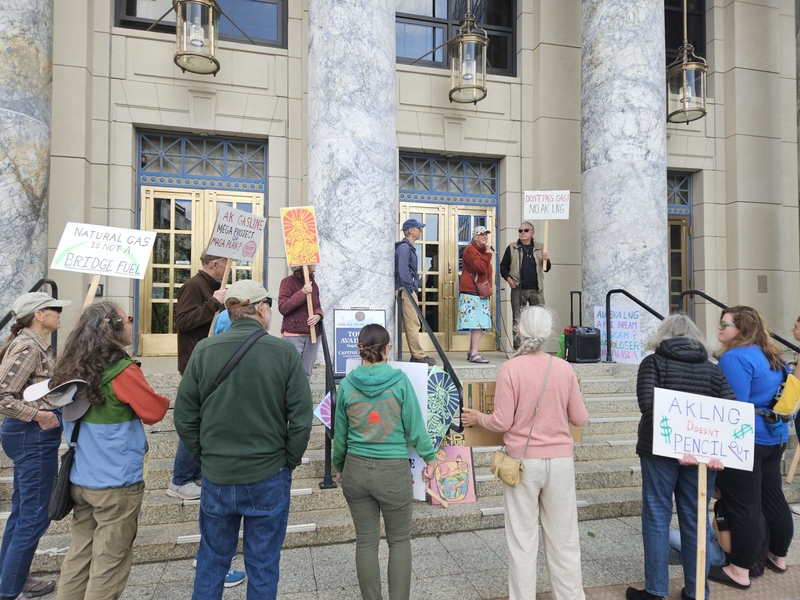 Demonstrators gather outside the Capitol on July 16, 2026 to protest the state providing tax cuts for the proposed AKLNG gas line project, and developing fossil fuels, the main driver of climate change. (Photo by Corinne Smith/Alaska Beacon)